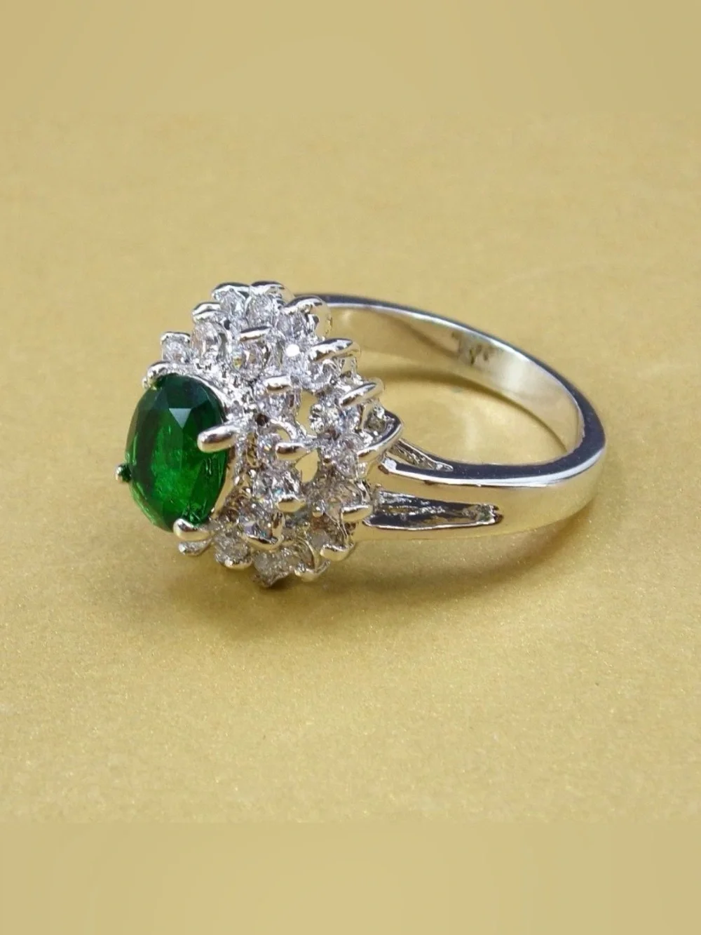 Green oval cubic zirconia stone ring w/ clear stones in a raised setting SZ 6.5